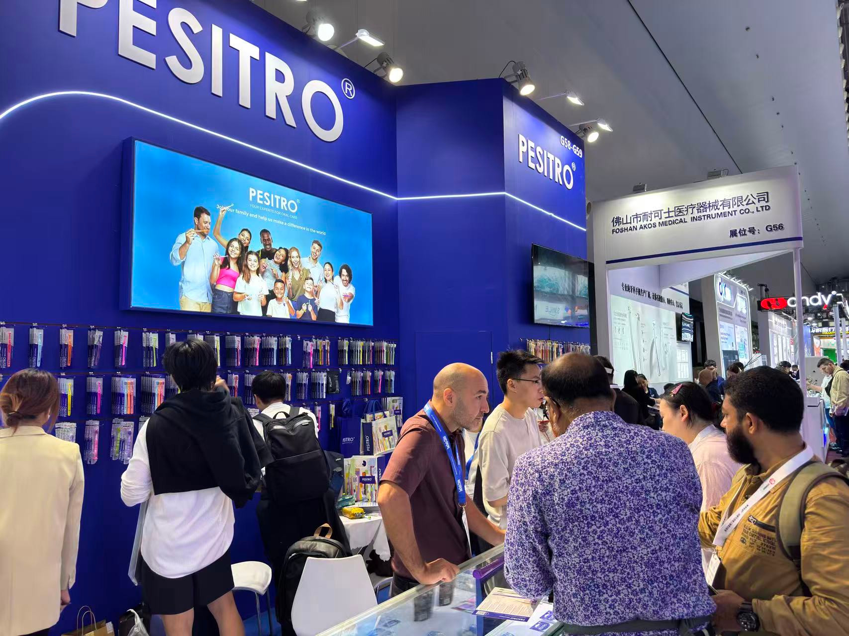 Visitors speaking with the PESITRO team beside oral-care product displays at DenTech China 2026.